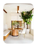 Cream-colored breakfast nook remodel in San Diego featuring built-in seating and a round wood dining table.