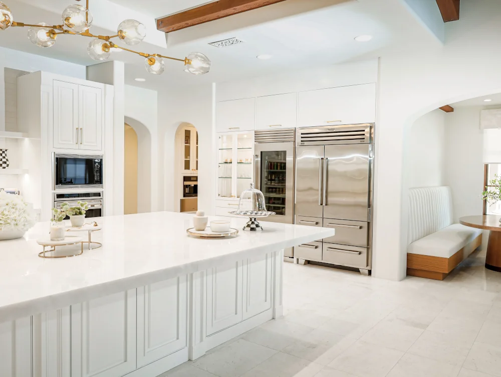 Modern kitchen with a marble waterfall island, white cabinetry, and open-concept design.