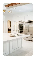 Modern kitchen with a marble waterfall island, white cabinetry, and open-concept design.